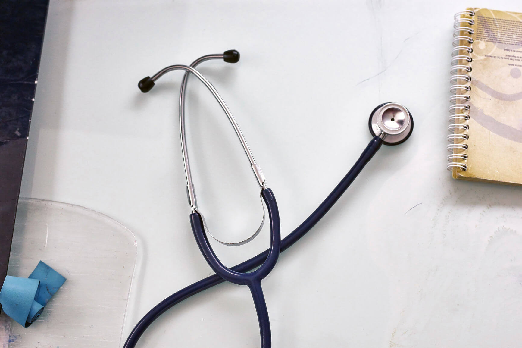 Stethoscope on desk with notepad.